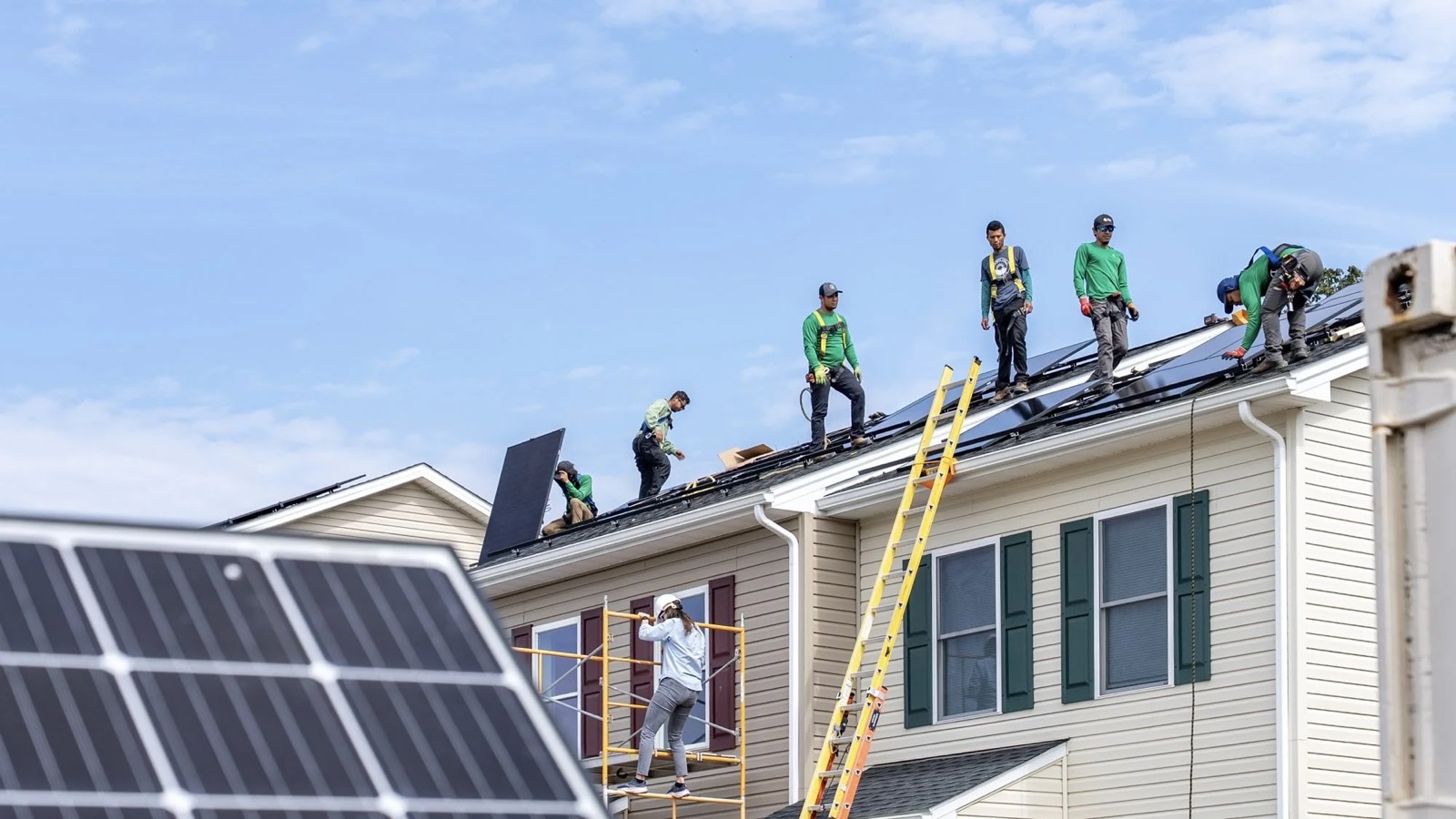 Volunteers raising panels onto a Habitat roof at the launch
